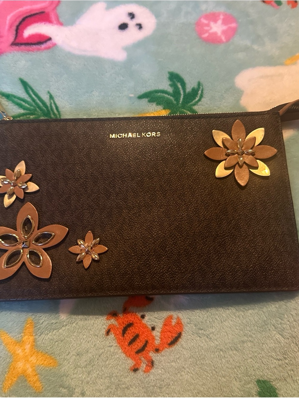 Michael Kors Daniela Large Leather/Sign Wristlet decorated floral appliqués.
